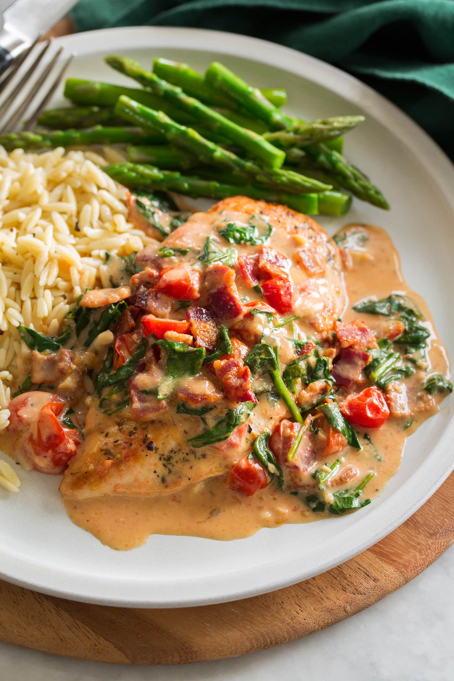 Smothered chicken served with orzo and asparagus.