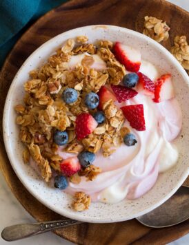 Granola, yogurt and fruit bowl shown from above.
