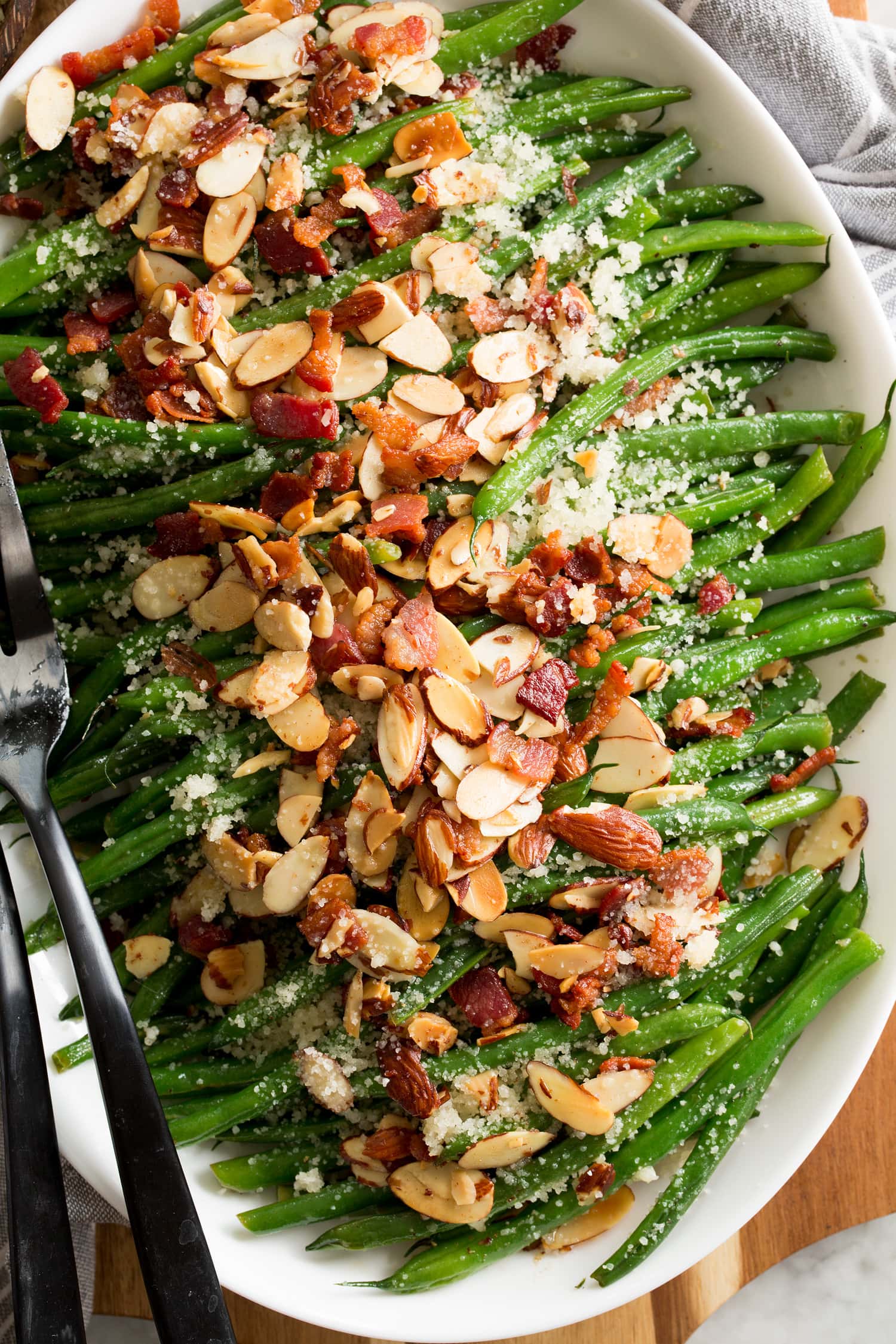 Close up photo of sauteed green beans with almonds, bacon and parmesan.