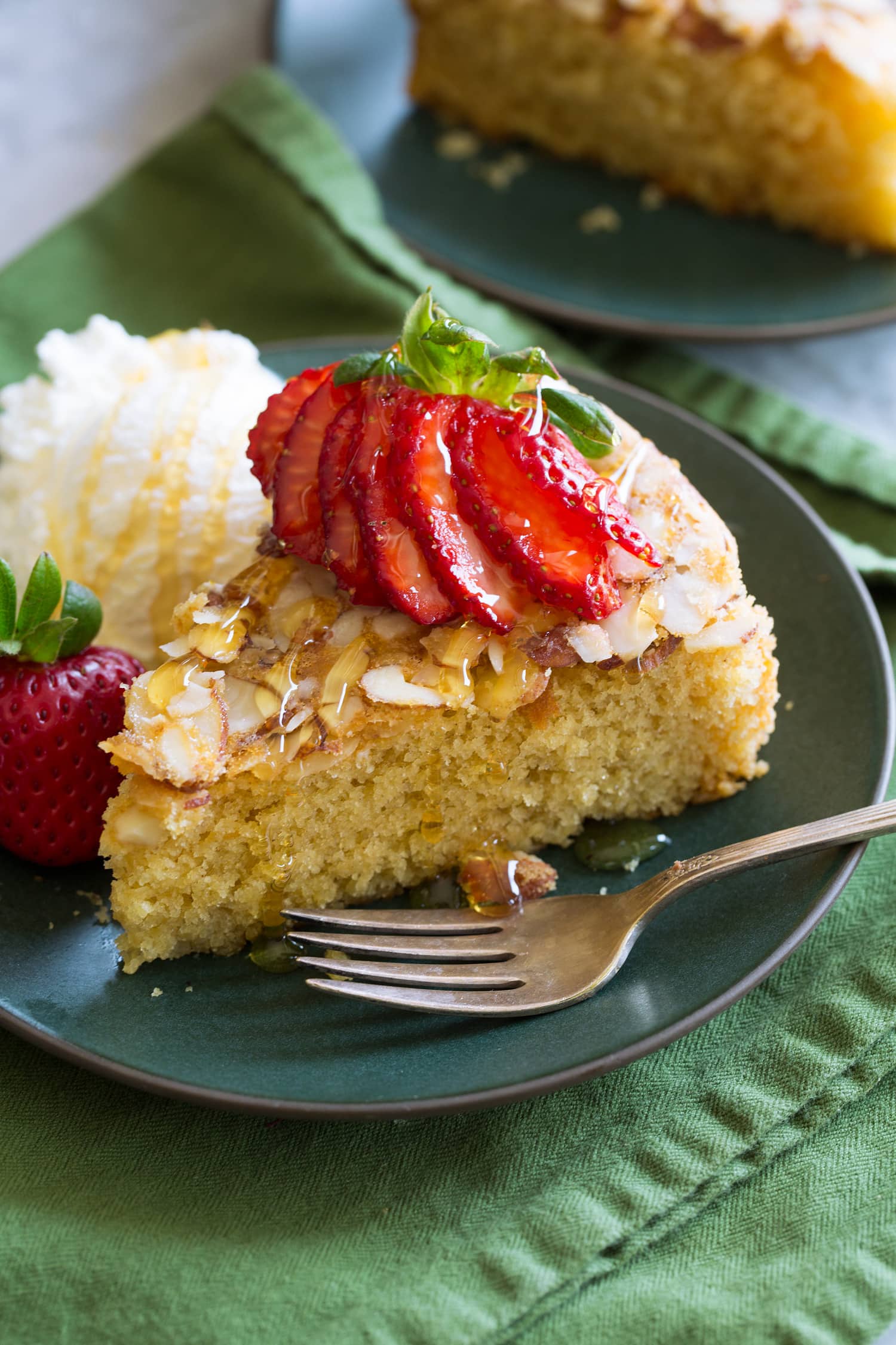 Honey cake shown with variation of serving with strawberries and ice cream.
