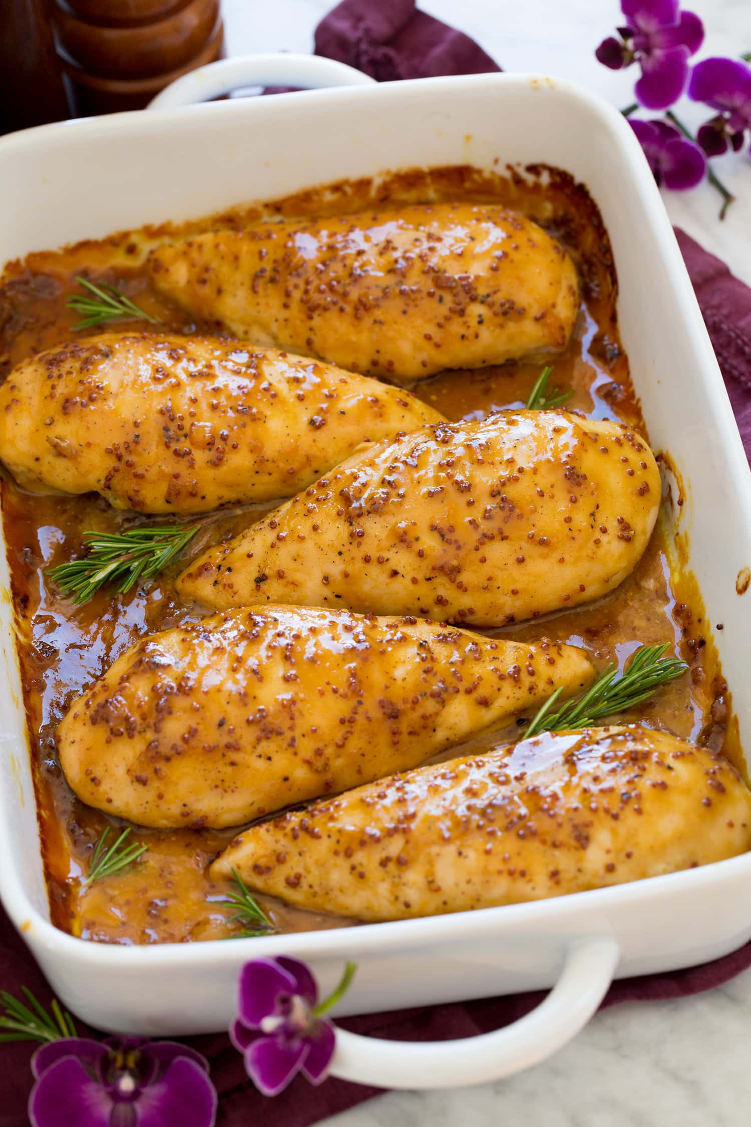 Honey mustard chicken in a baking dish lined up in a row.