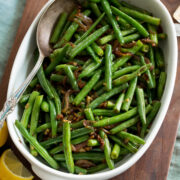 Sauteed fresh green beans shown in a white serving dish.