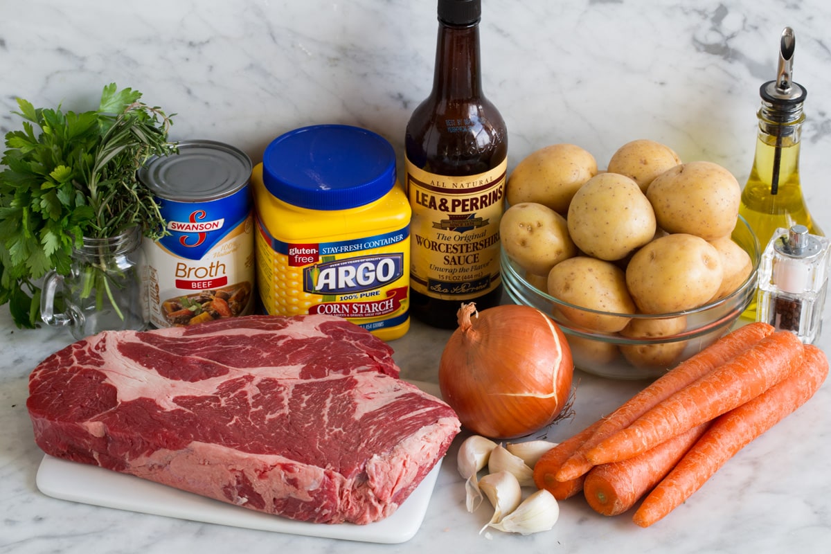Ingredients needed for crockpot pot roast including chuck roast, yellow potatoes, carrots, onion, garlic, herbs, Worcestershire, beef broth, garlic, and cornstarch.